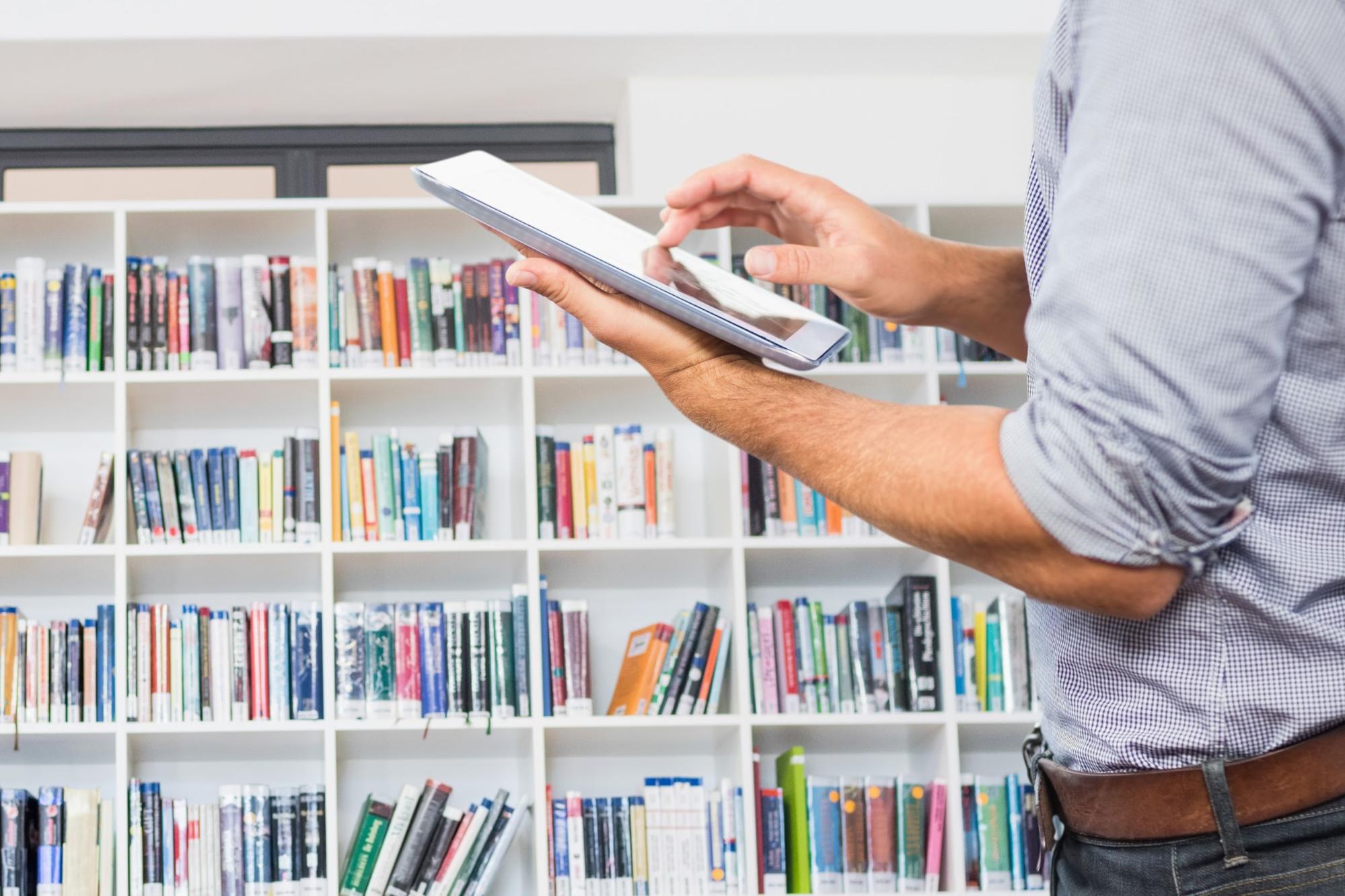 man using a tablet in a library